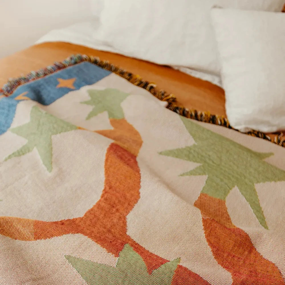 Close-up of a quilt with star and moon patterns on a bed.