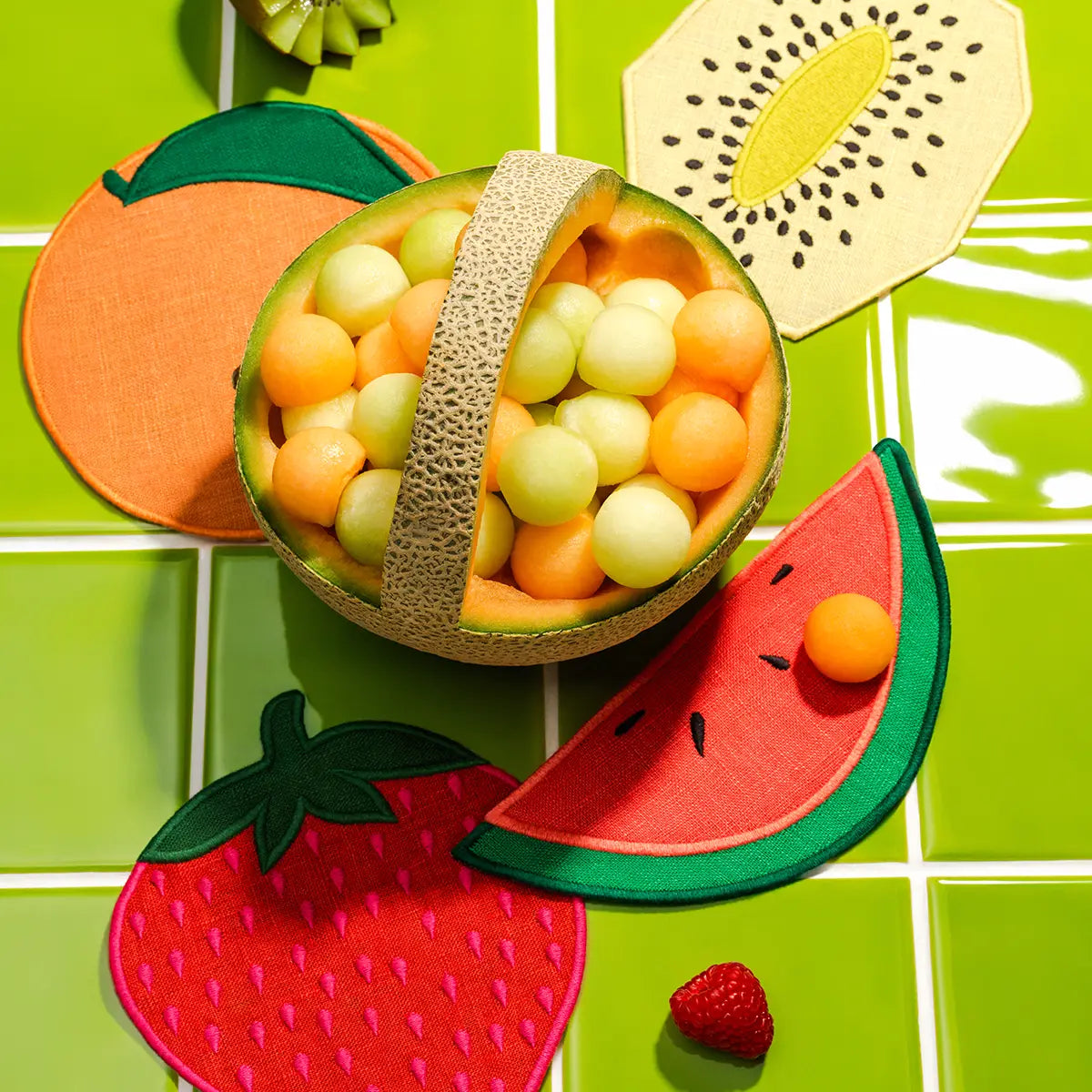 Fruit-themed coasters on a green tiled background