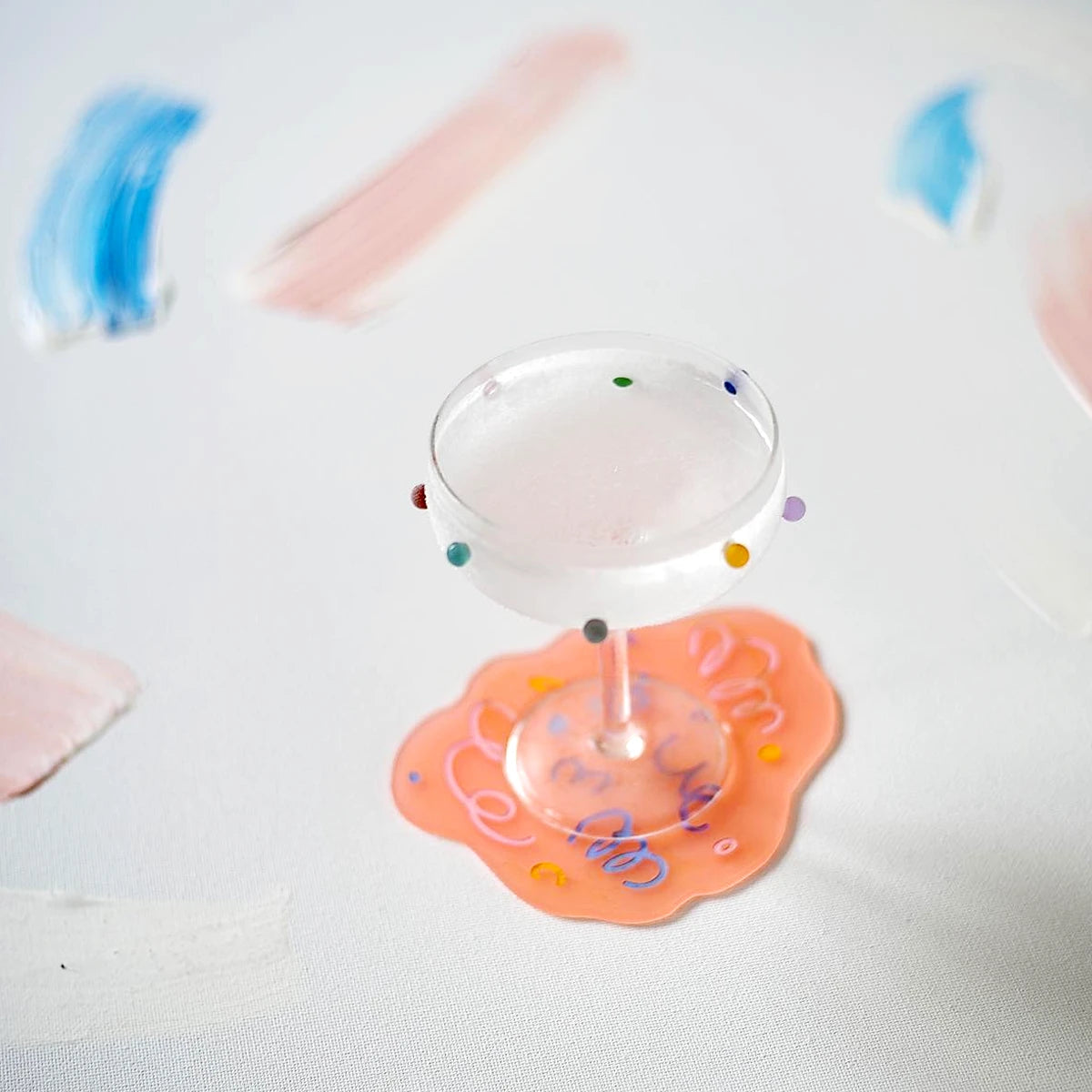 Two cocktail coupe glasses with colorful dot patterns by Maison Balzac