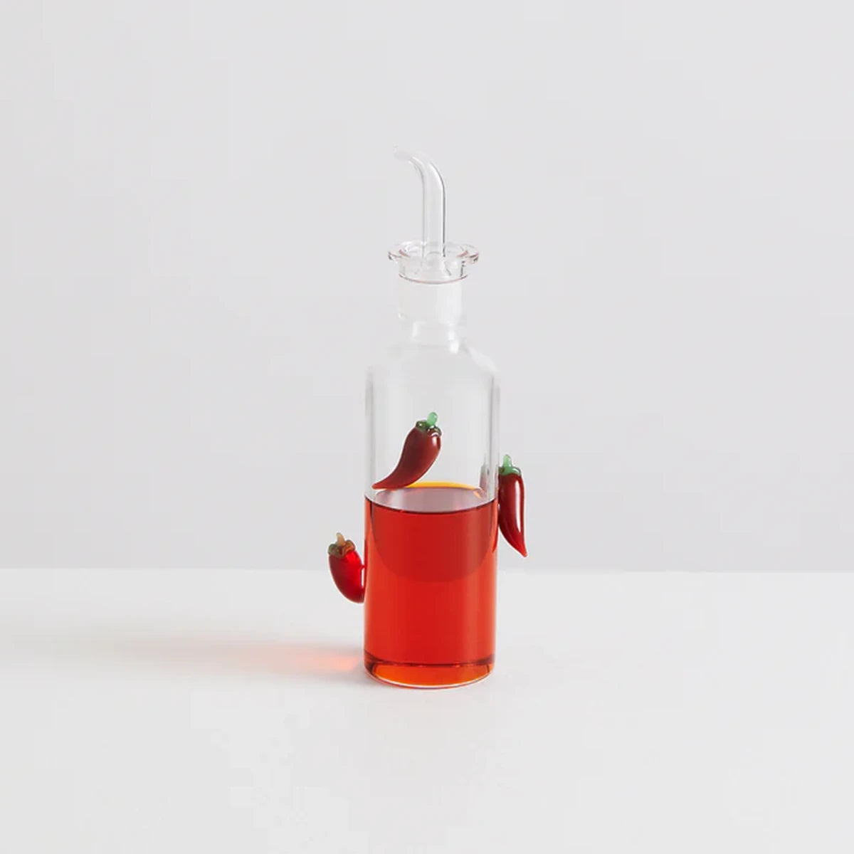 Glass carafe with chilli oil and decorative chili peppers with spout for pouring