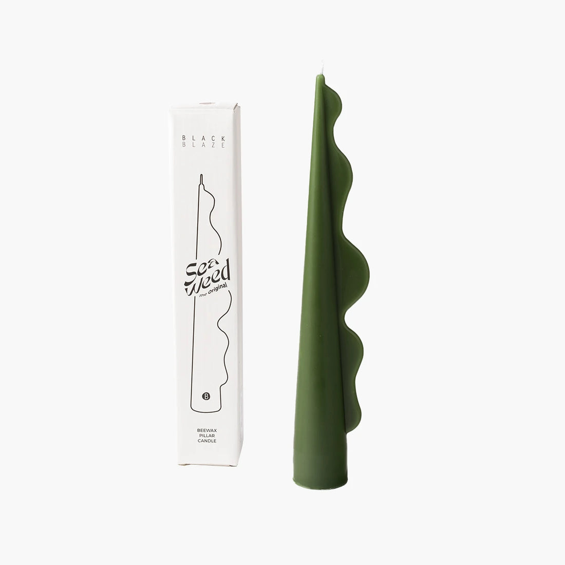 Green candle with wavy design next to its packaging on a white background
