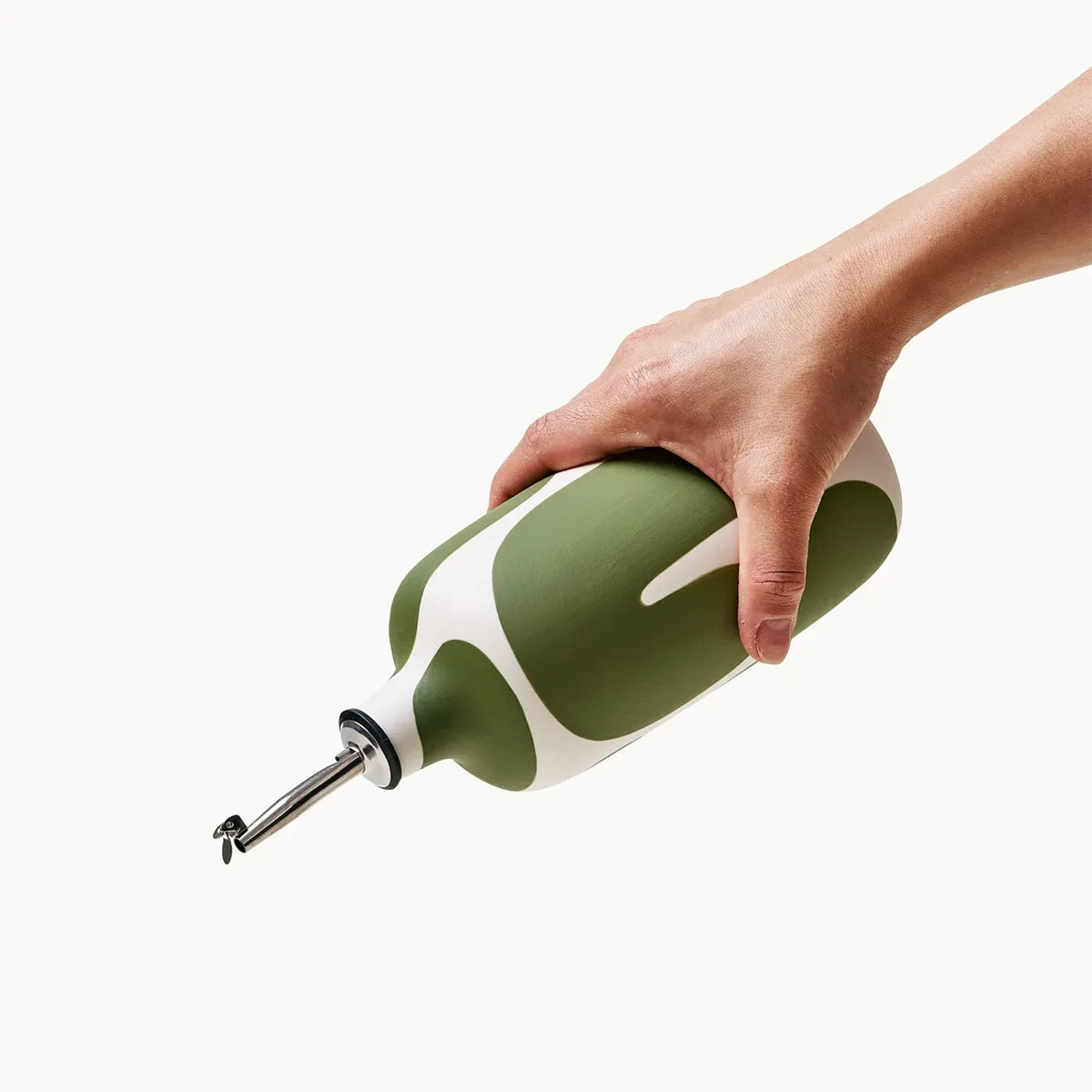 Hand holding a green and white bottle on a white background