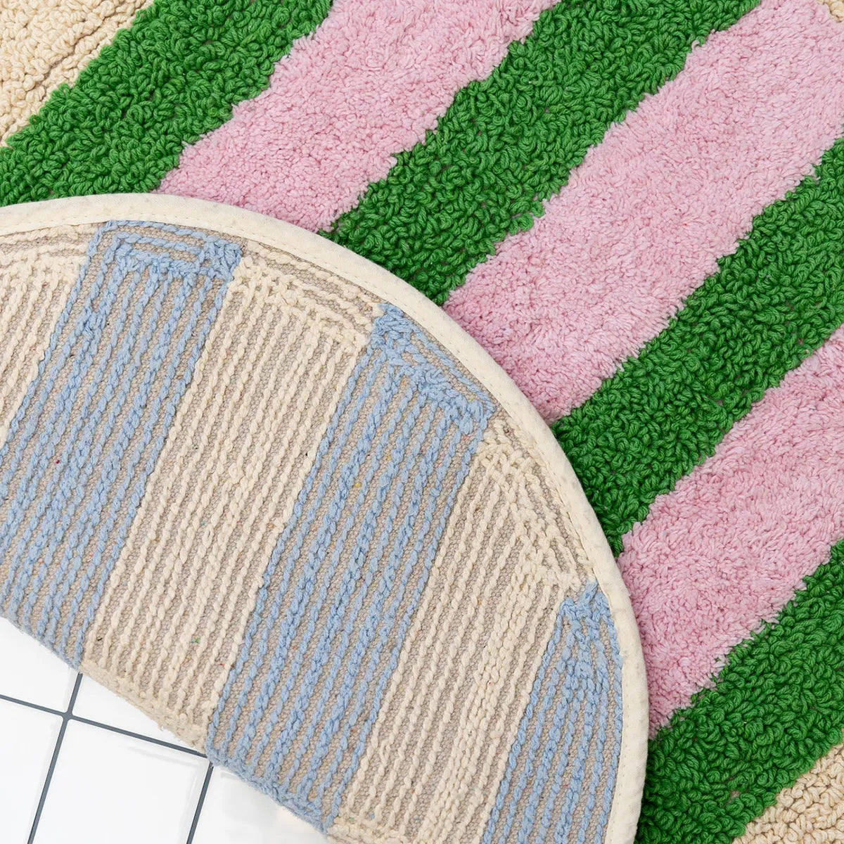 Round textured rug with multicolored stripes on a grid background