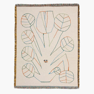 Decorative blanket with abstract leaf pattern on a beige background