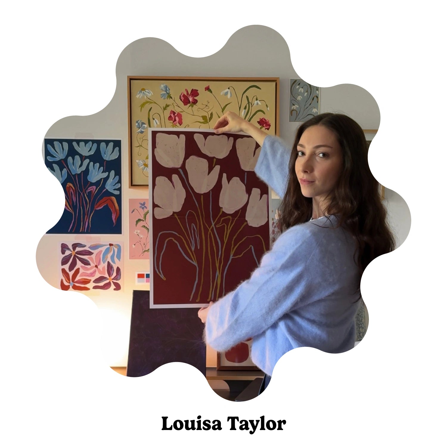 Portrait of English artist Louisa Taylor holding an art featuring painted flowers.